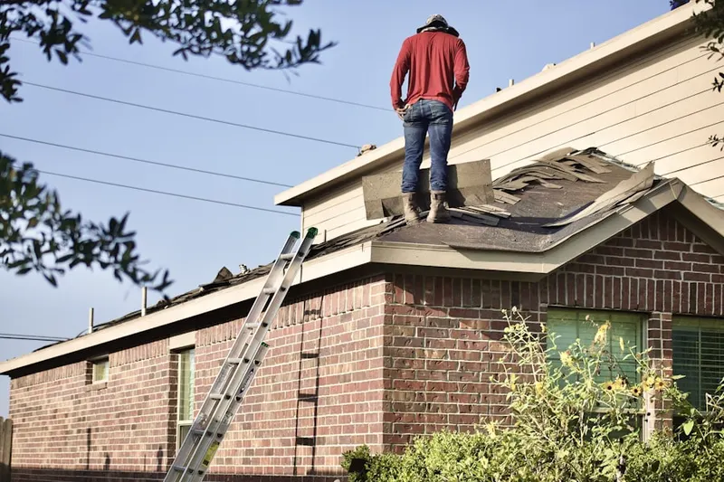 Professional roofer working on a residential roof in Coilton